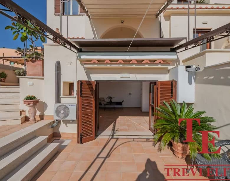 Elegant Italian townhouse terrace with terracotta flooring, lush potted plants, and stylish shutters; perfect for outdoor living.