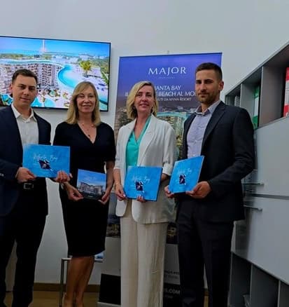 Modern real estate team at Trevi Elite holding property brochures in an office setting, promoting high-end Italian properties to clients.