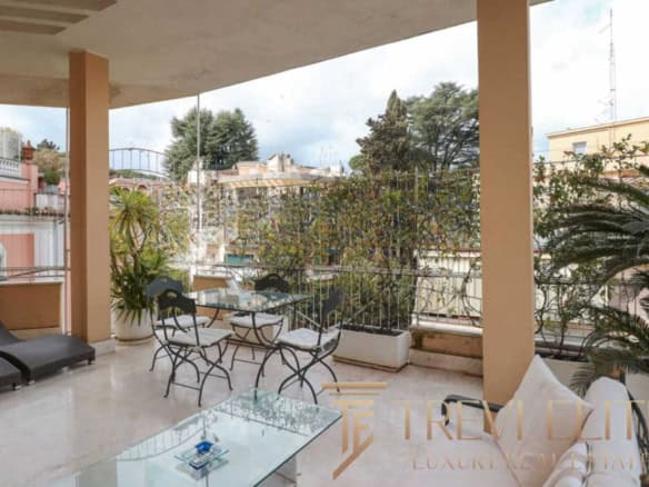 Elegant outdoor balcony with stylish seating and lush greenery, offering a luxurious Italian living experience in a prime location. Perfect for relaxing or entertaining amidst scenic city views.