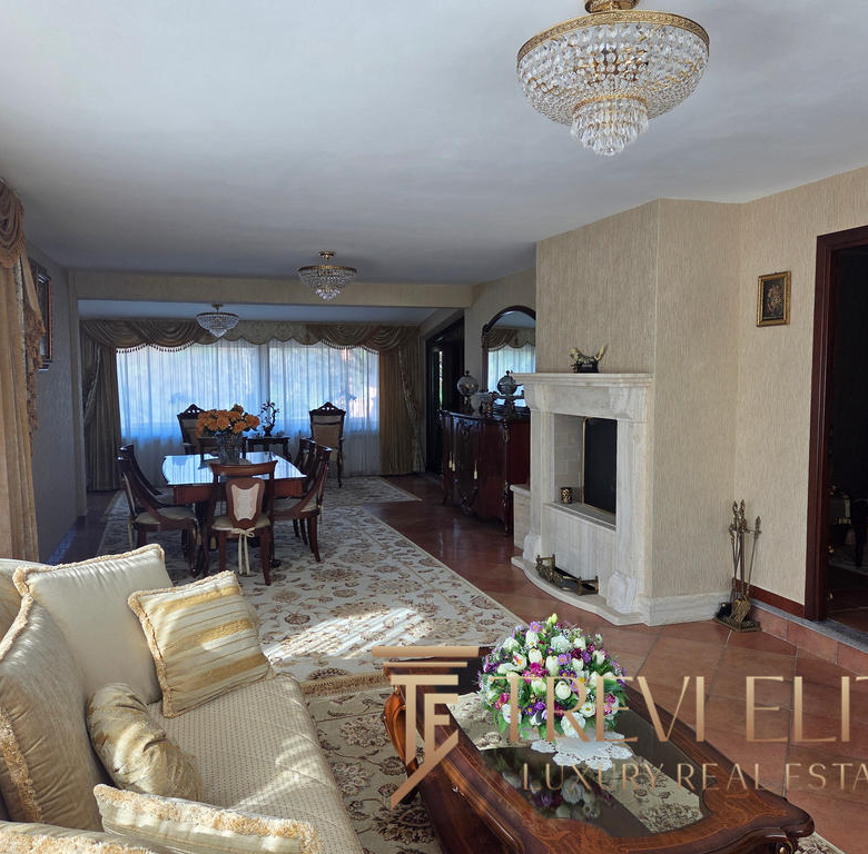 Elegant Italian living room with luxurious furnishings, ornate chandelier, and classic decor, featuring a spacious open-plan layout with a dining area and fireplace, perfect for upscale real estate listings.