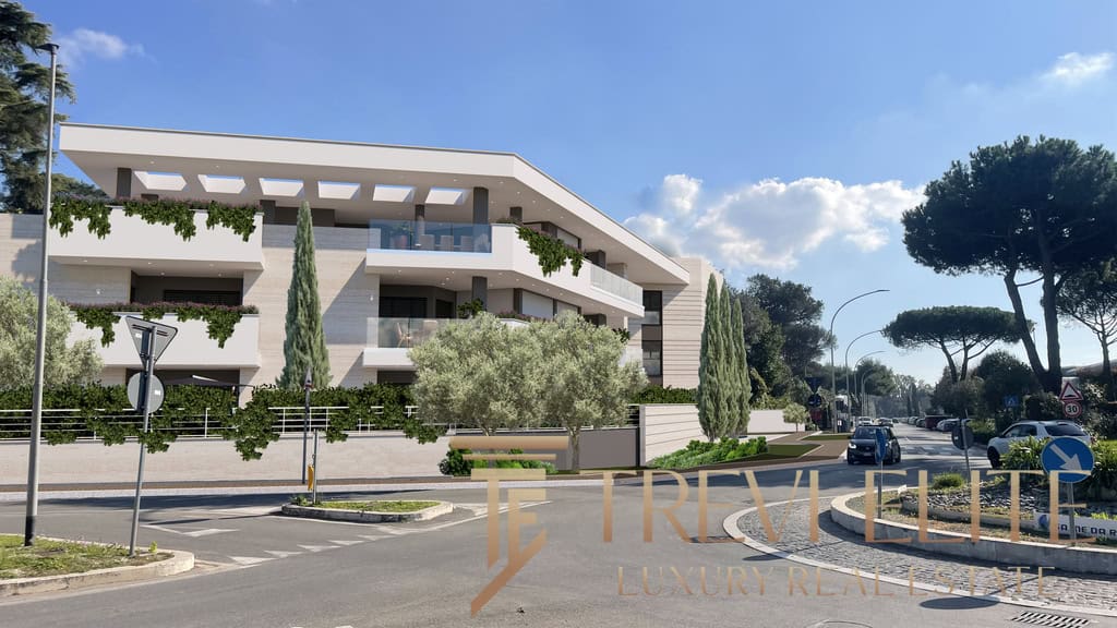 Contemporary white multi-storey residential building with lush greenery, tall cypress trees, and modern balconies, situated on a sunny street with parked cars and clear blue sky.