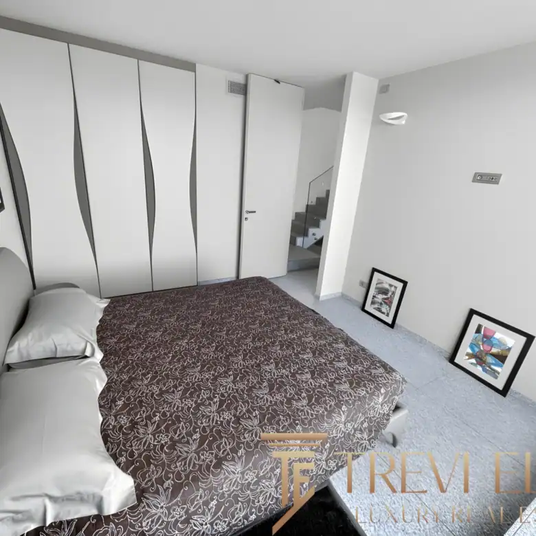 Modern walk-in closet with white cabinetry and ample storage space.