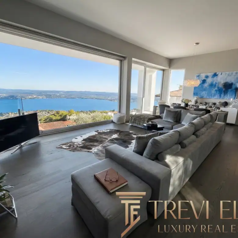 Living area featuring a long grey sofa and dark wood shelving.