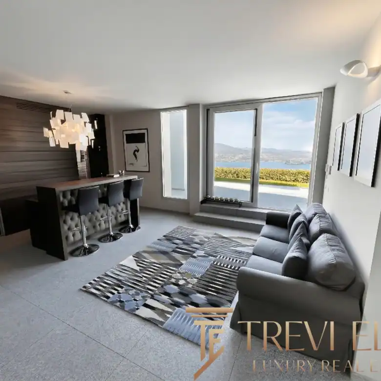 Living room with a unique wooden accent wall and lake views.