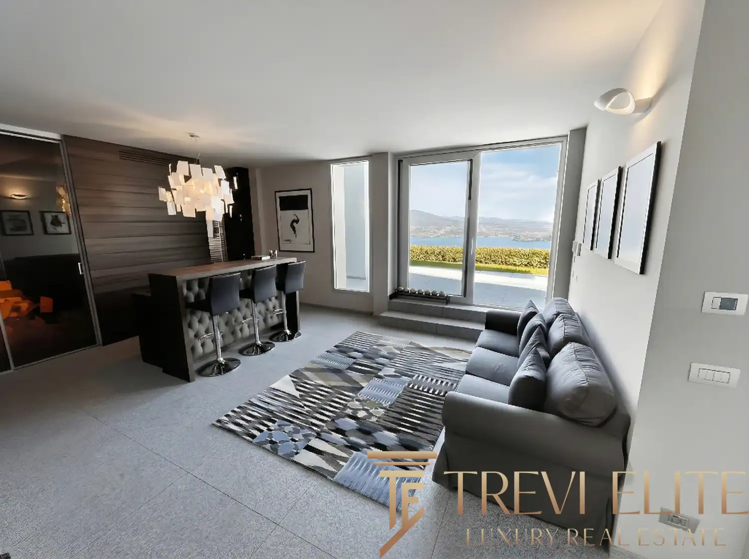Living room with a unique wooden accent wall and lake views.