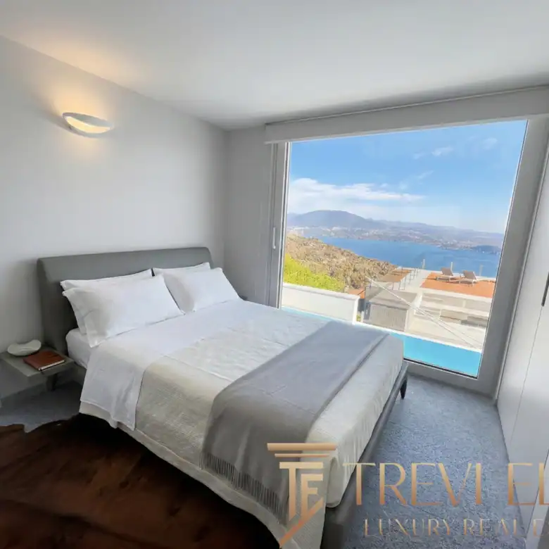 Bedroom featuring white bedding and a direct view of the rooftop pool.