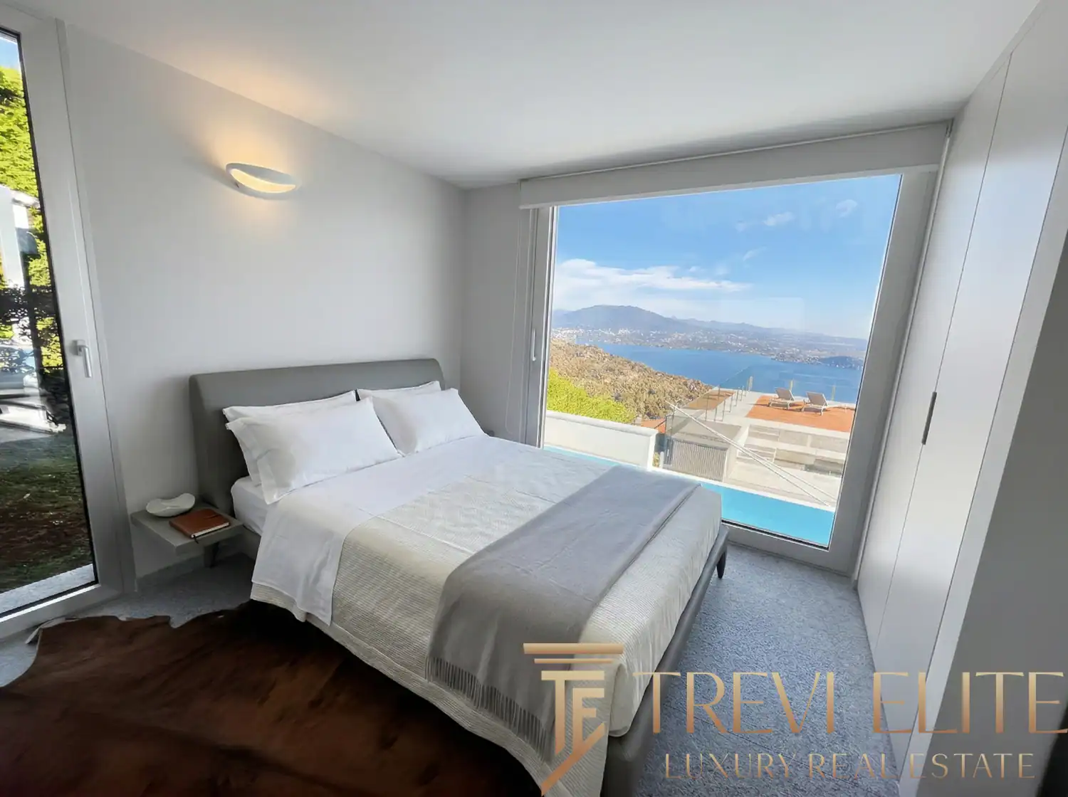 Bedroom featuring white bedding and a direct view of the rooftop pool.
