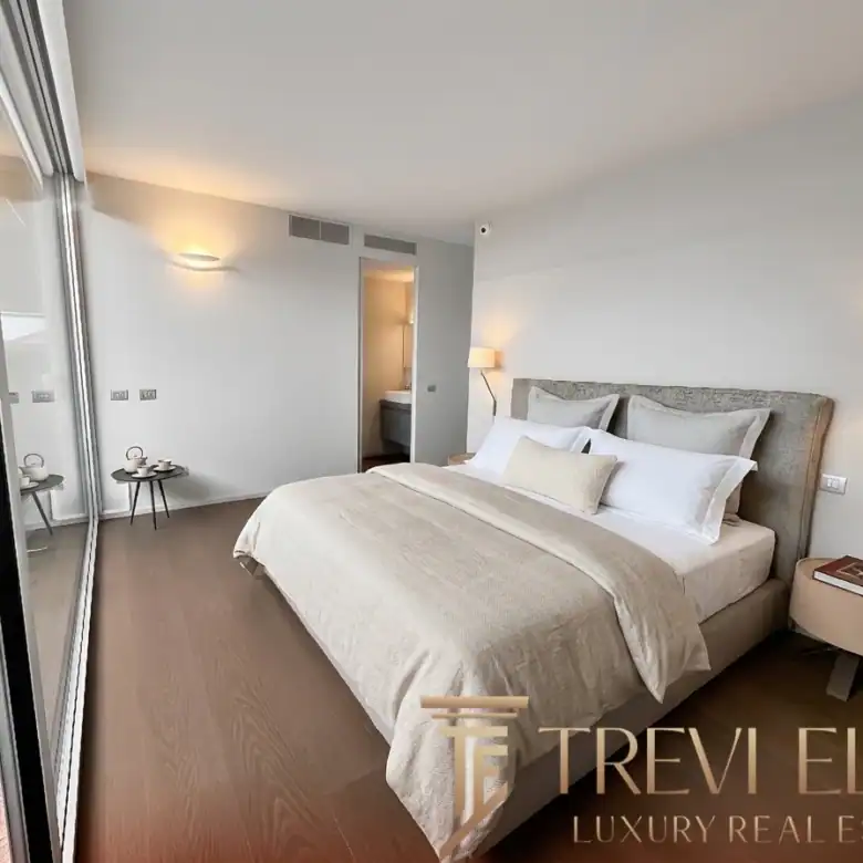 Bright bedroom with a large window and a minimalist wooden desk.