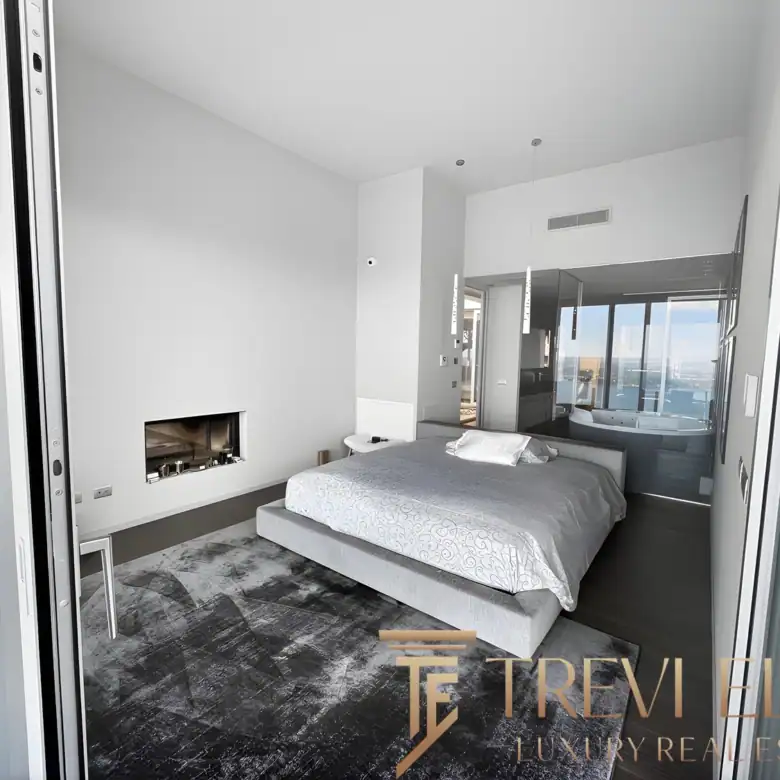 Minimalist bedroom with a built-in fireplace and grey-toned decor.