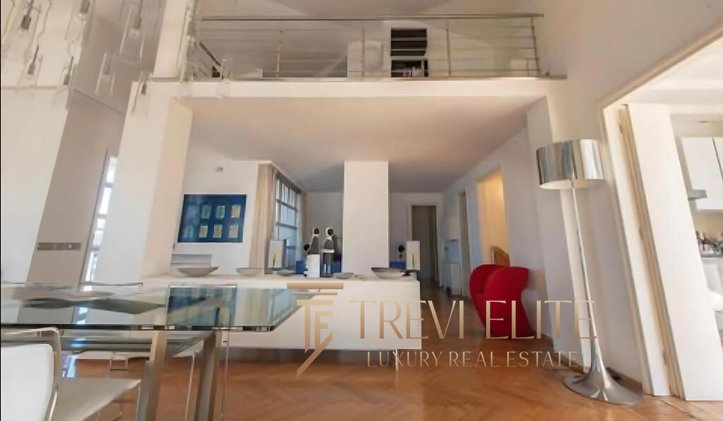 Spacious modern living room with open-plan design, stylish furnishings, large windows, and high ceilings, offering luxurious comfort and panoramic natural light in an elegant Italian property.