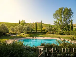 Luxury villa in Montalcino with private pool, cypress trees, and vineyard views in Val d'Orcia, Tuscany.
