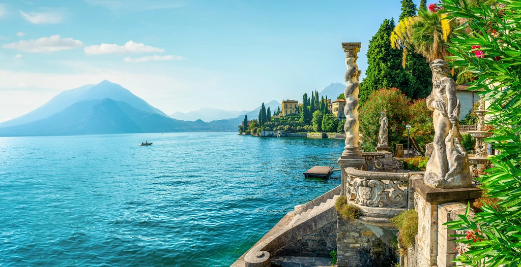 Neo-classical Lake Como villa with cypress trees and private waterfront access overlooking the Italian Alps.