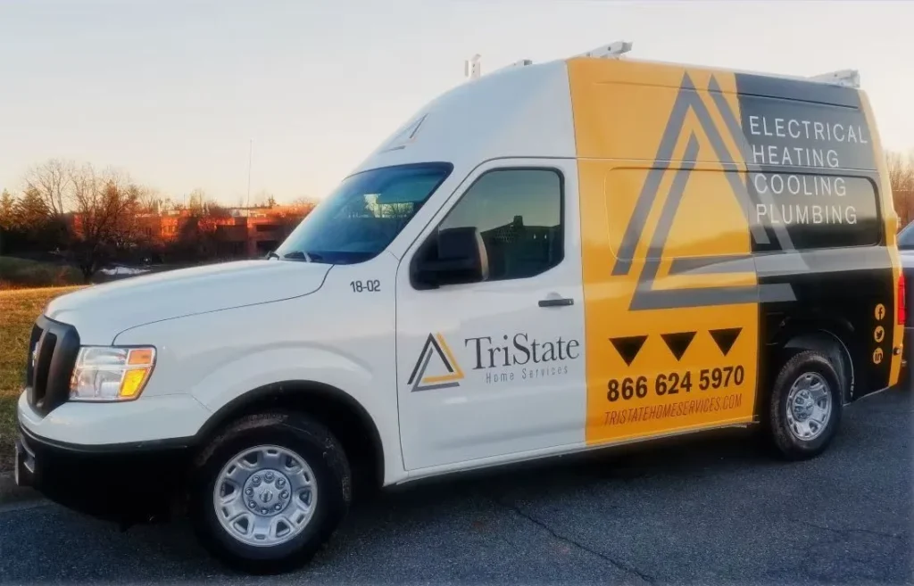 A White And Yellow Tristate Home Services Van Is Parked On The Road, Advertising Electrical, Heating, Cooling, And Plumbing Services With A Contact Number Visible. Explore Careers In These Essential Services With Us—Tristate Is Always Hiring Skilled Professionals.