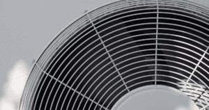 Close-Up View Of A Metallic Fan With A Circular Grille. The Fan Blades Are Visible Through The Gaps. The Image Is Predominantly Black And White With A Minimalistic Design.