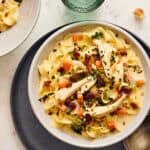 Creamy chicken and vegetable noodle soup with bacon, fresh herbs, and tender pasta served in a white bowl. Perfect for cozy meals and easy comfort food recipes.