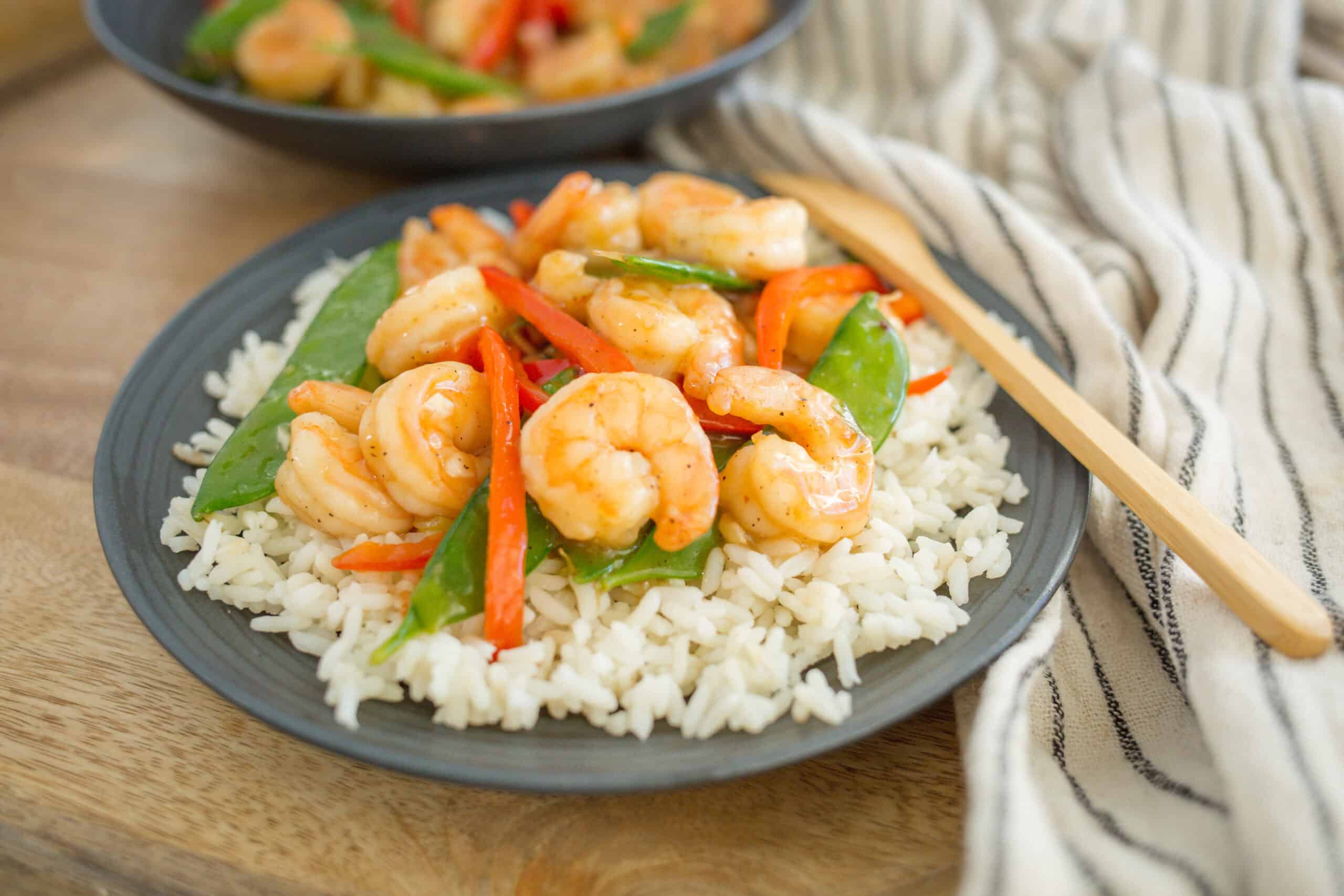 Succulent shrimp stir-fry with colorful bell peppers served over fluffy white rice, perfect for quick and delicious Asian-inspired dinner recipes.