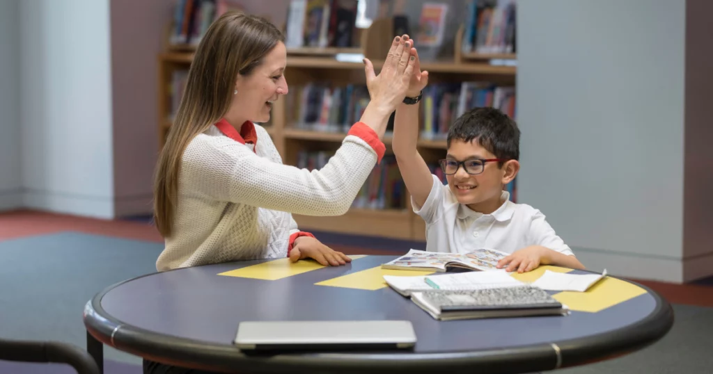 female tutor and male student doing a high five