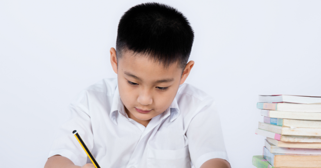 a person sitting at a desk with a notebook and pencil