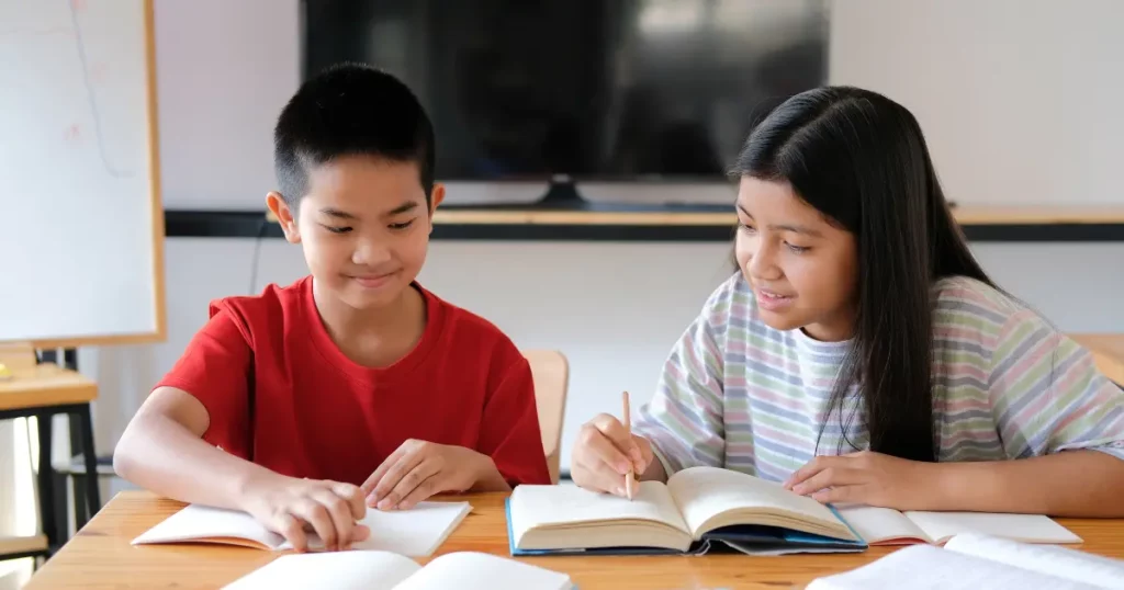 two children sitting at a table with books | tuitioncentre SG
