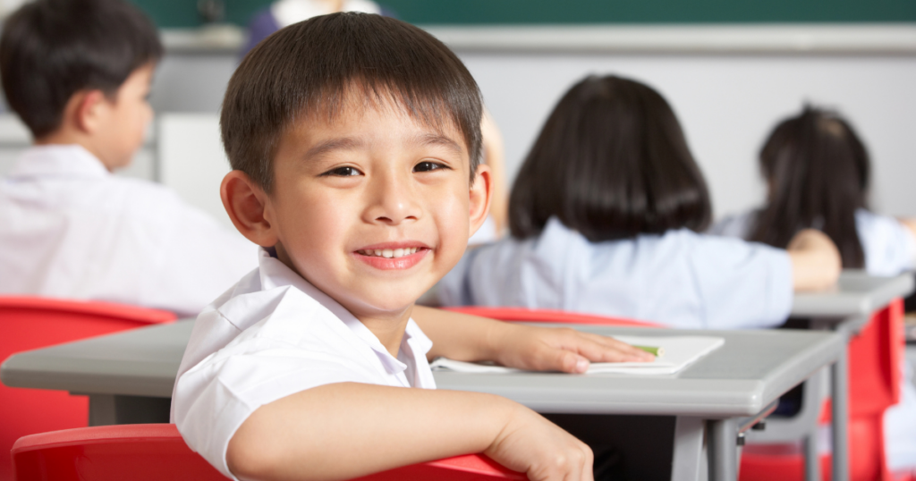 a child sitting at a desk in a classroom