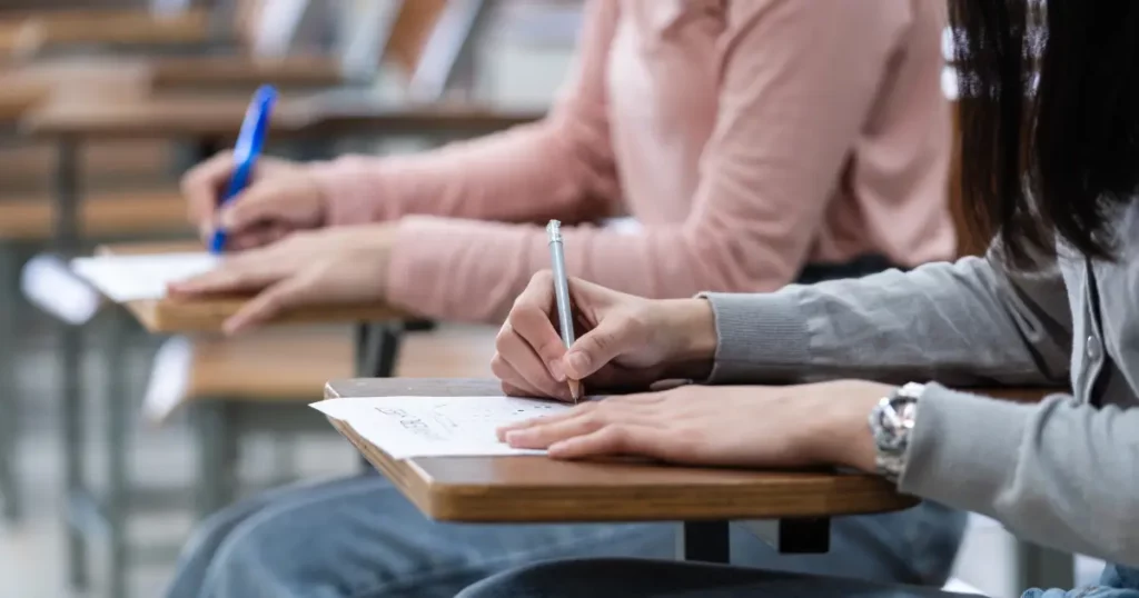 a group of people sitting at desks in an auditorium | tuitioncentre sg