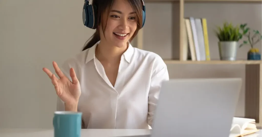 A tutor wearing headphones in front of a laptop computer | tuitioncentre sg