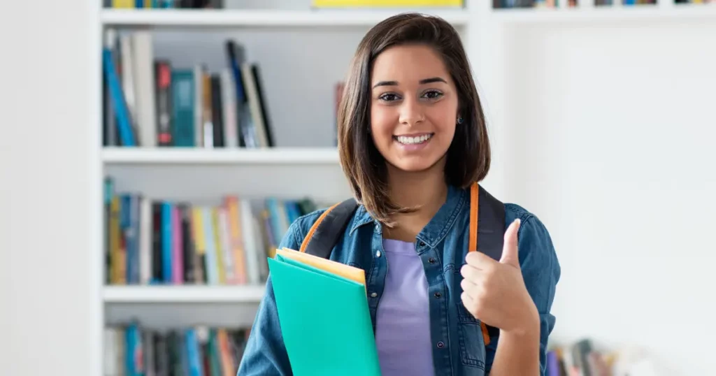 A smiling student holding a folder and giving a thumbs up | tuitioncentre sg