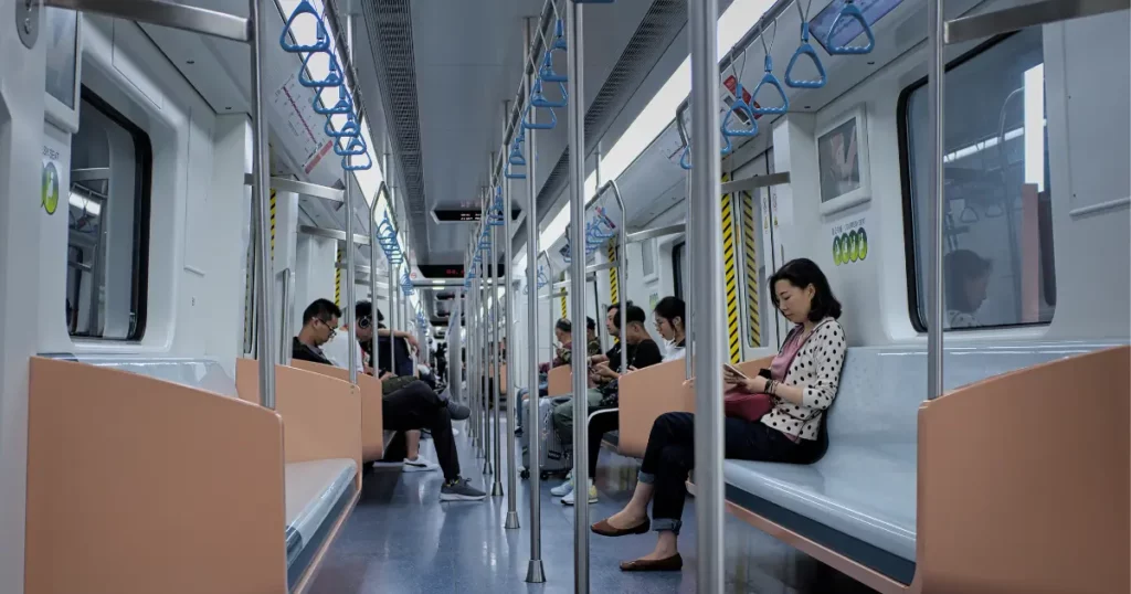 the interior of a subway car with people sitting on the seats | tuitioncentre sg