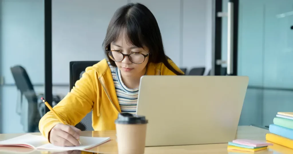 A person working on their laptop in an office | tuitioncentre sg