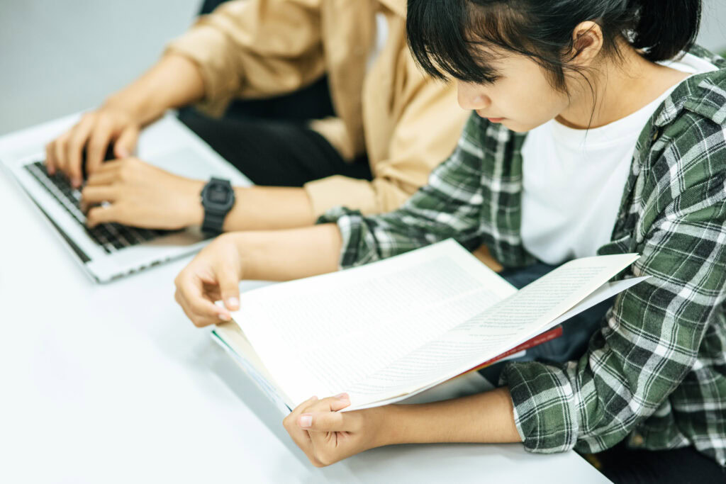 Women read books and men use laptops to search for books in libraries | Tuition Centre SG