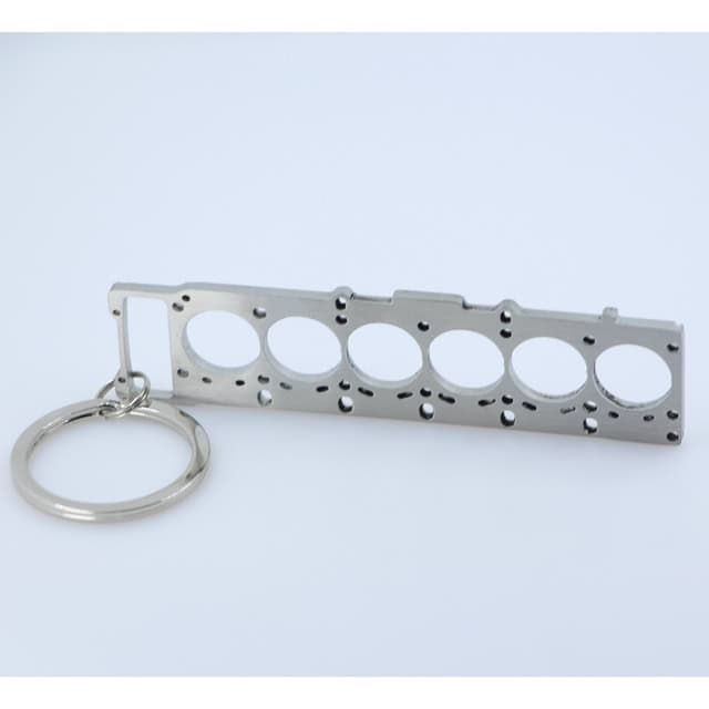 Detailed metal engine block keychain replica, perfect for car lovers and automotive enthusiasts, featuring a realistic engine part design.