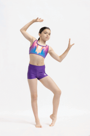 Gimnasta de perfil con el top Prisma Glow y shorts ajustados, mostrando el estampado prismático inspirado en luz solar