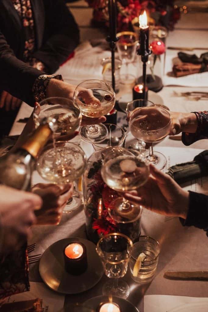Cheers to celebration, wine glasses clinking at elegant dinner party.