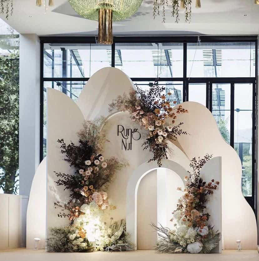 Elegant floral event backdrop with modern design and decorative arches for weddings and celebrations at UpEventi.