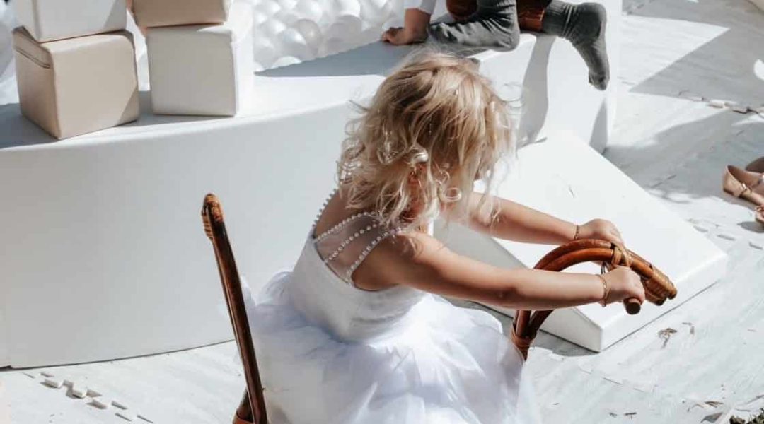 Kids enjoying a playful outdoor event with a white ball pit and vintage-style toys.