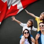 Canadian flag waving, happy family traveling in Canada, exploring the country together.