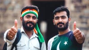 Two men with flags of Pakistan and India, showing unity and support.