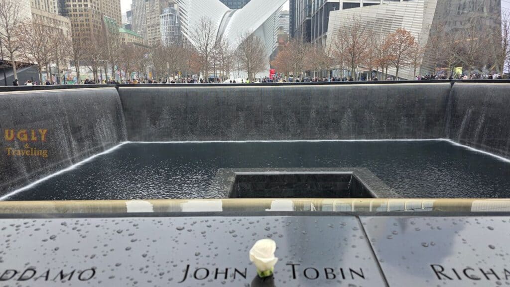 9/11 Memorial reflecting pool with names inscribed, somber tribute in New York City.