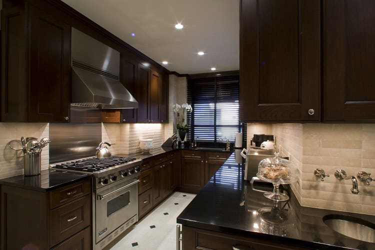 Contemporary urban kitchen featuring dark wood cabinets, stainless steel appliances, and sleek black.