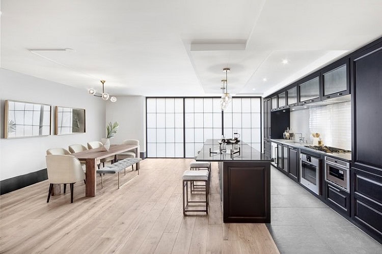 Contemporary urban kitchen and dining space with sleek black cabinetry and minimalist design.