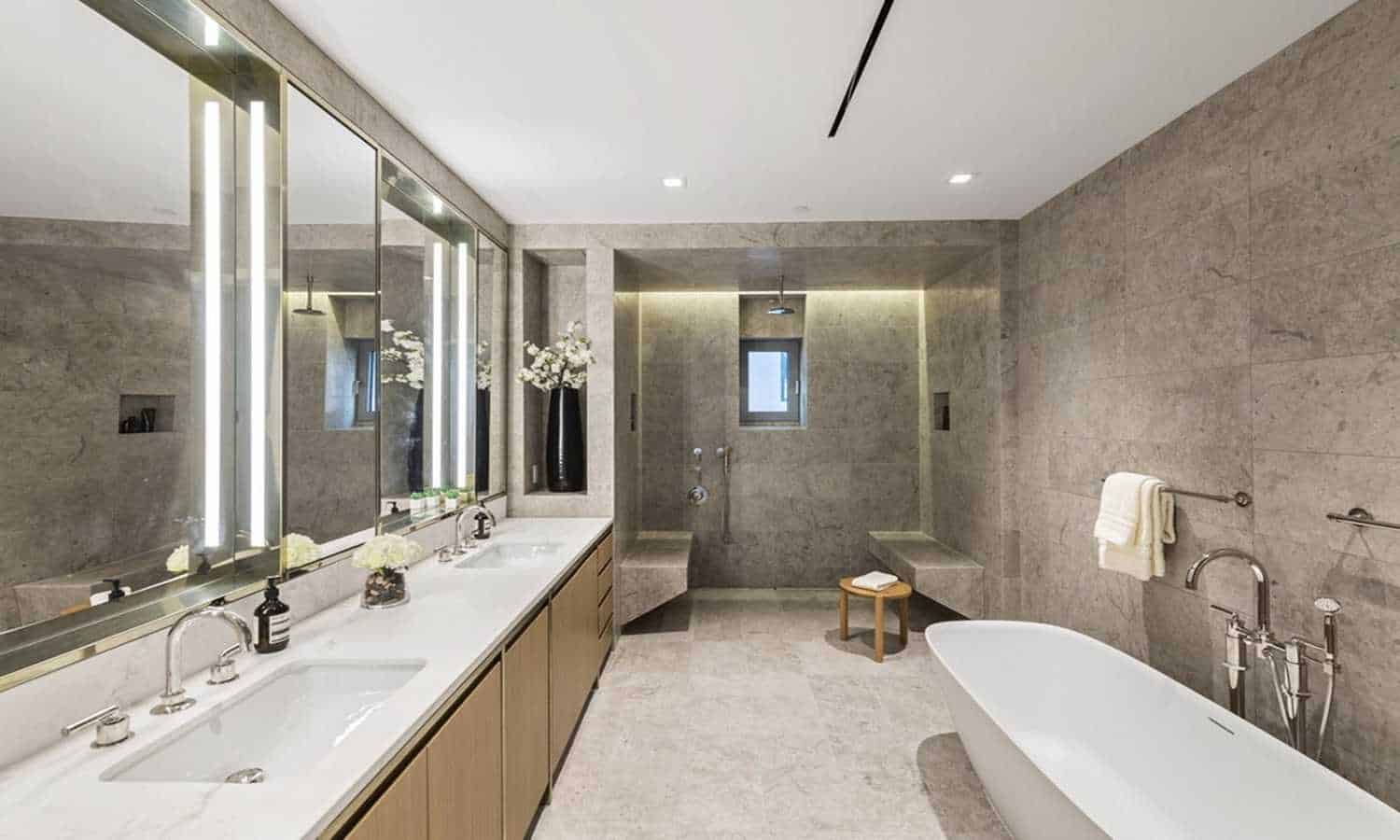 Spacious urban bathroom featuring modern fixtures, a freestanding bathtub, and sleek decor for conte.