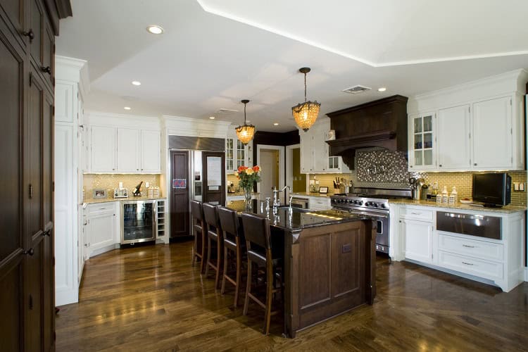 Urban Homes kitchen featuring white and dark wood cabinetry, stainless steel appliances, and a spaci.