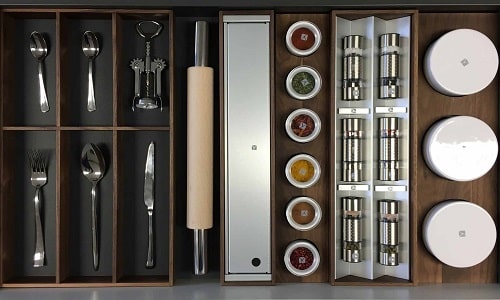 Efficient kitchen drawer with utensils, spices, and storage solutions for urban homes.