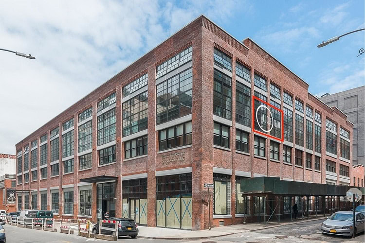 Modern brick commercial building in an urban setting with large glass windows.
