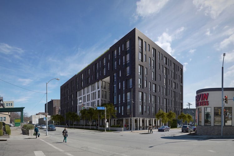 Contemporary urban apartment building with sleek black and white facade in city center.