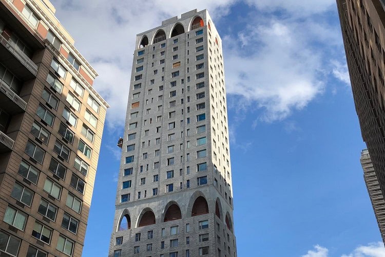 Modern high-rise building with unique architectural design in a cityscape.