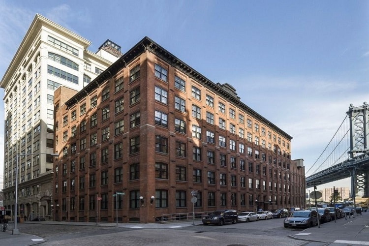 Urban residential building with classic brick architecture in a bustling city environment.