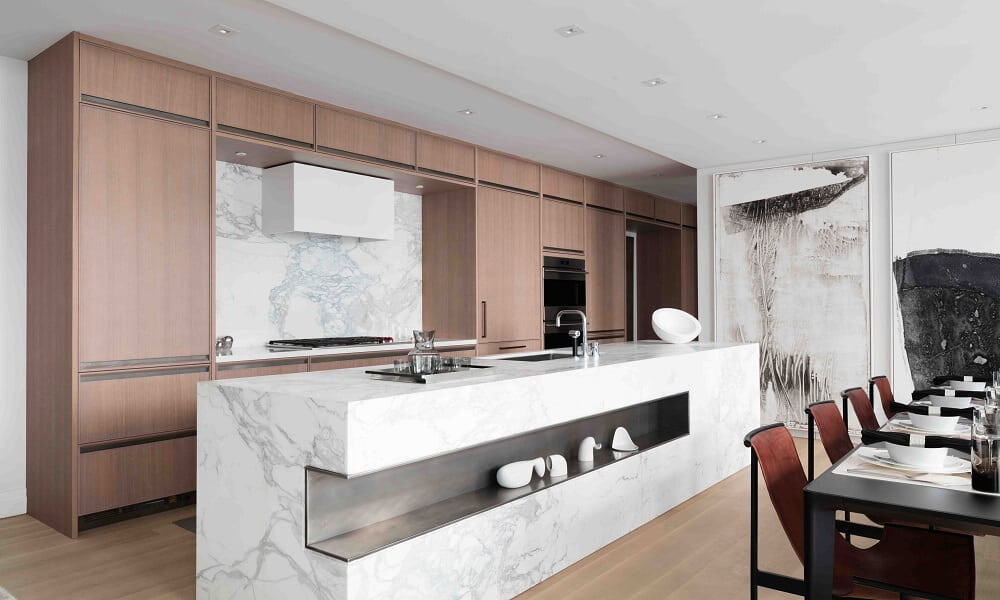 Modern kitchen featuring a marble island, wooden cabinetry, and sleek appliances for contemporary ur.