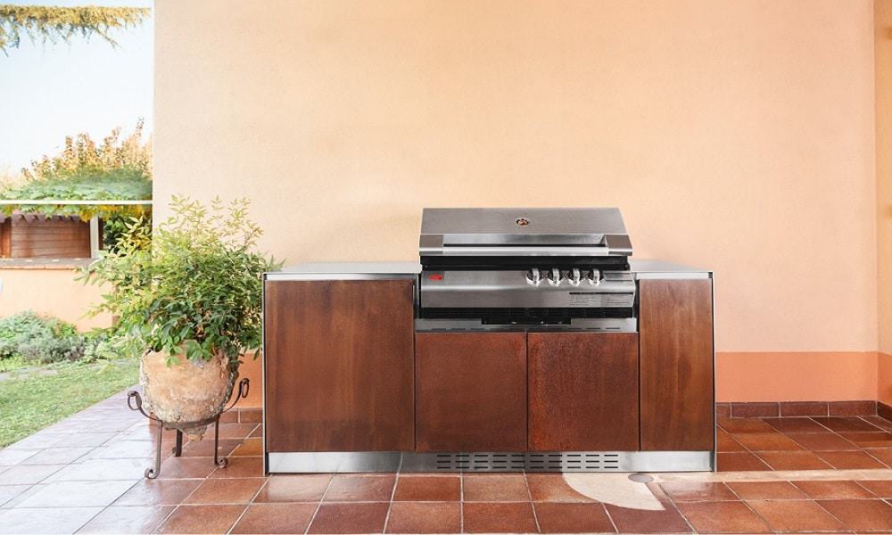 Outdoor kitchen with built-in stainless steel grill and wooden cabinets for outdoor cooking.