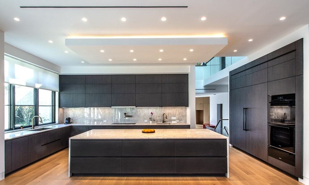Urban Homes modern kitchen with black cabinets and marble countertops for contemporary living.